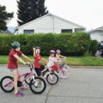 Four kids in the road on bikes riding