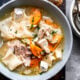 Cooked turkey noodle soup in white bowl.