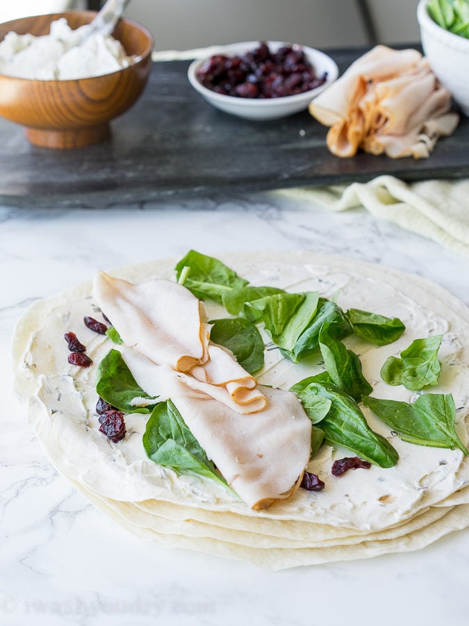 These Turkey Cranberry Pinwheels are filled with a creamy cream cheese, spinach, turkey and cranberries! Perfect for lunch or appetizers!