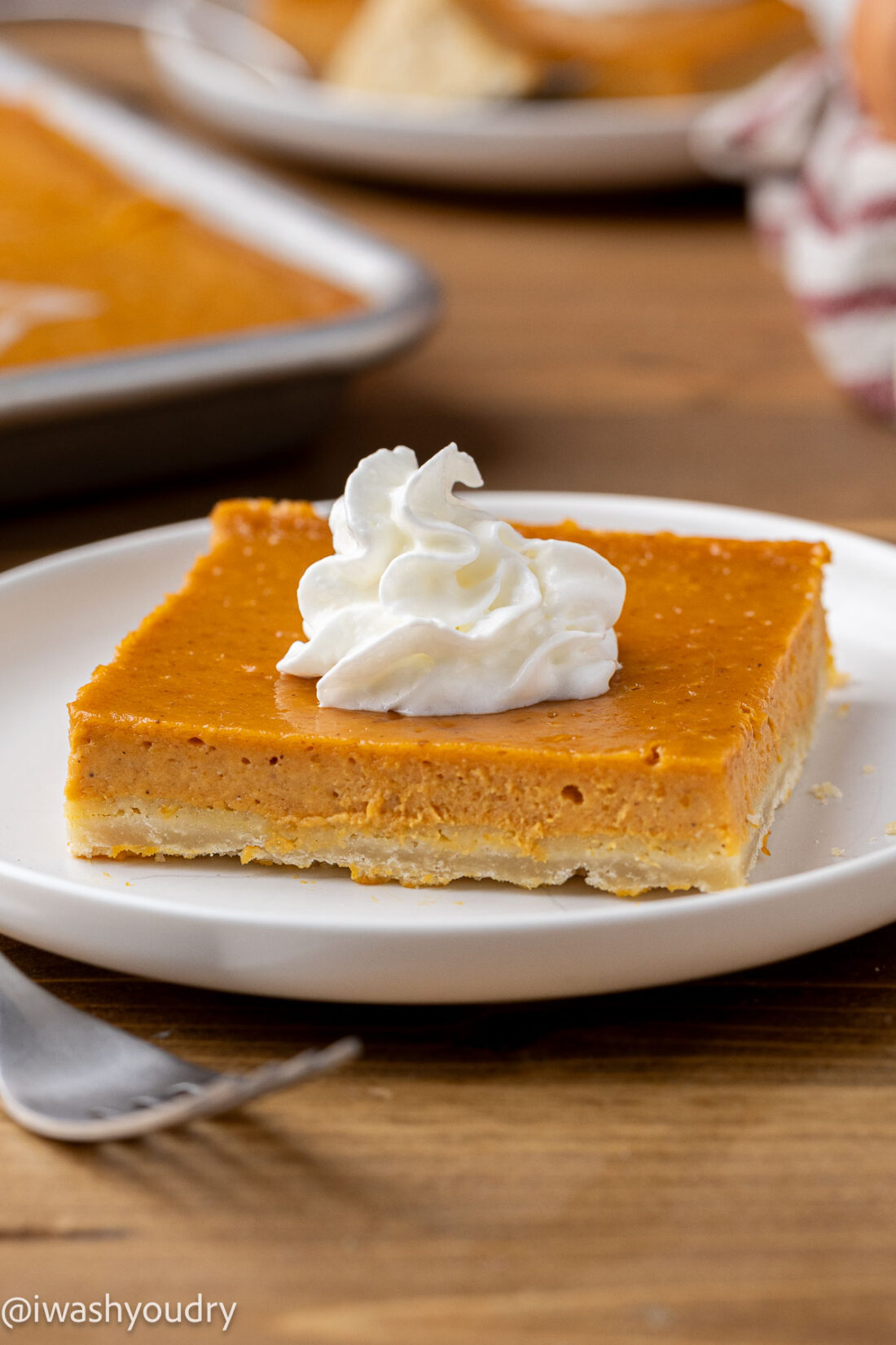 Sliced of baked pumpkin pie bar on a white plate.
