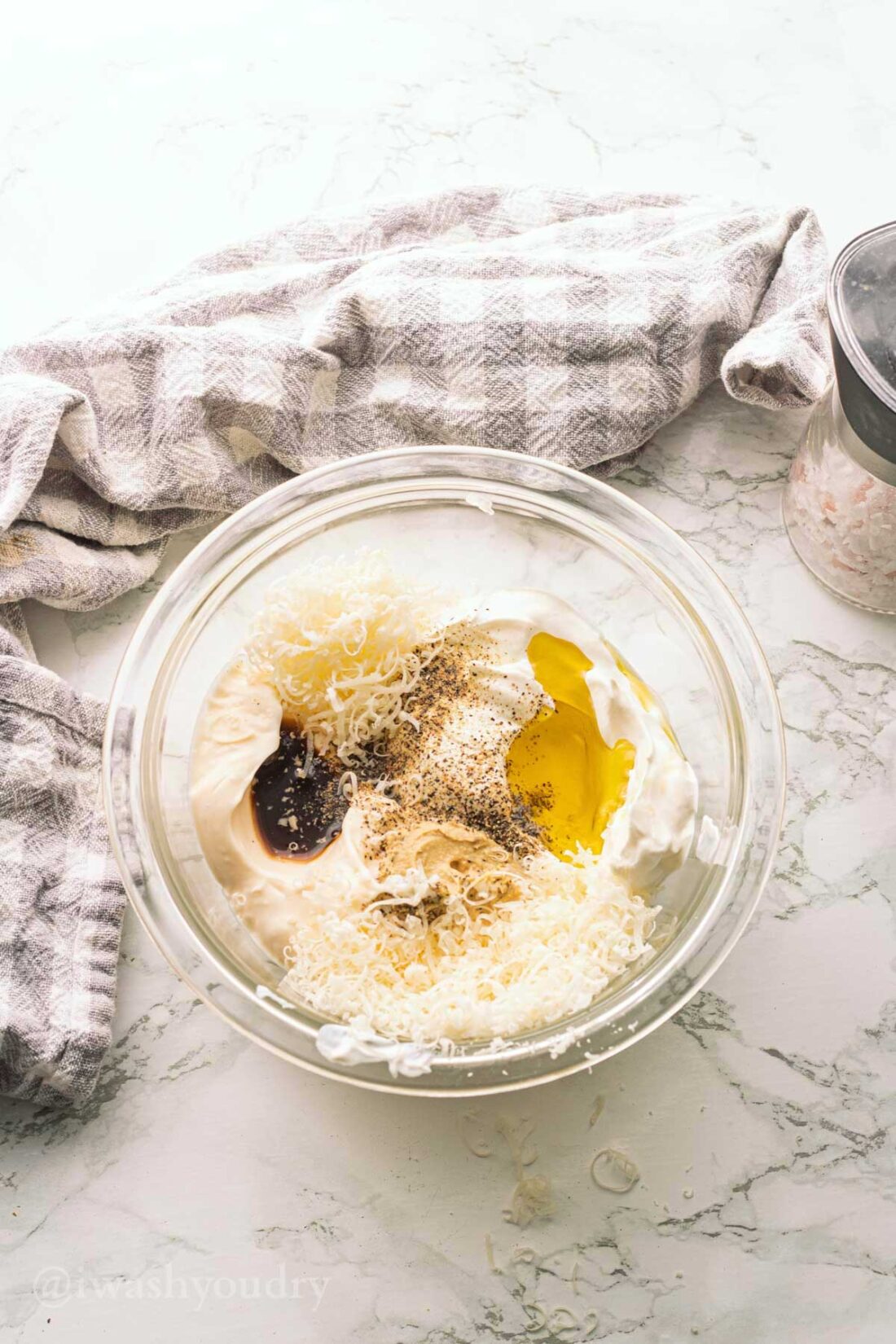 Mayo, sour cream, olive oil, parmesan cheese, worcestershire sauce, pepper, and mustard in glass bowl.