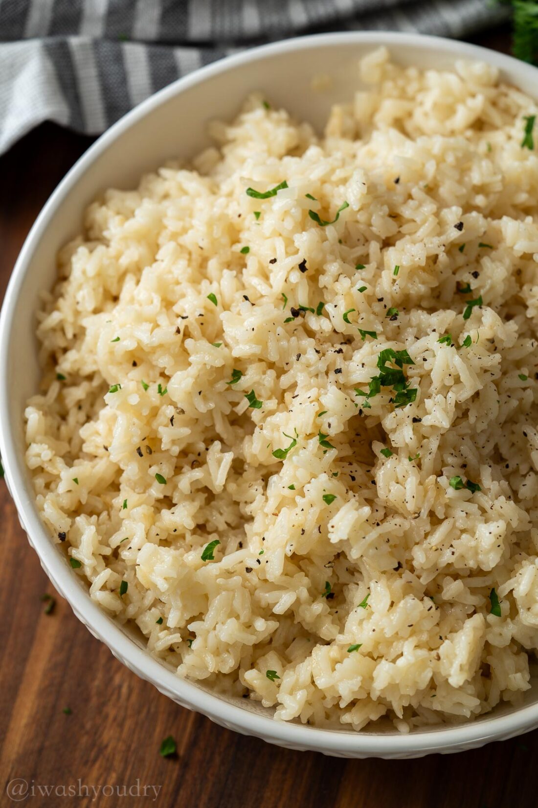 White rice cooked with pepper on top in white bowl.